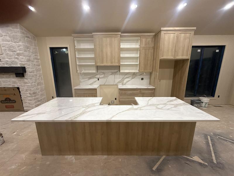 White quartz island with soft gold veining and a matching full-height backsplash