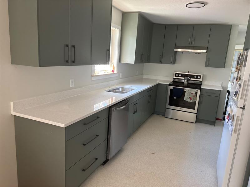 Sparkle white quartz countertop with a backsplash lip on sage green cabinets