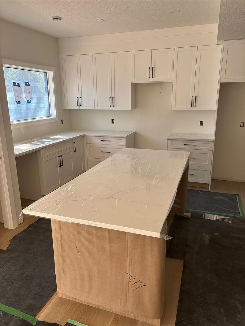 White shaker upper and lower cabinets with matte black pulls